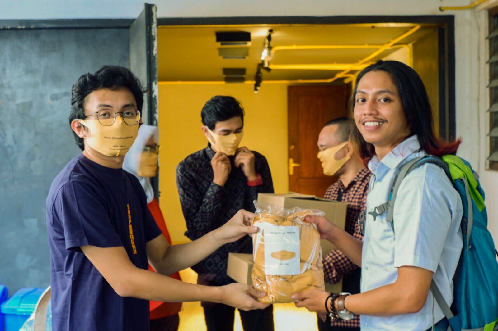 VP of Operations Sampingan - Ryan Dwi Putra (kiri) menyerahkan masker secara simbolis kepada salah satu Kawan Sampingan di Jakarta (18/5/2020). Melalui kampanye #BuatOrangRumah Sampingan membagikan ribuan masker kepada para Kawan Sampingan yang masih bekerja di luar rumah serta berkolaborasi dengan Masker Kain Untuk Semua dengan membagikan masker kepada masyarakat yang membutuhkan. Hal ini dilakukan untuk menekan penyebaran covid-19 dan membantu mereka yang terkena dampaknya.